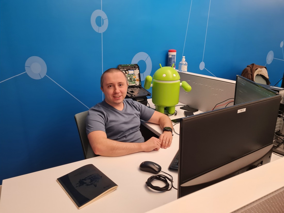 Andrei Trubin at his desk beside an Android mascot figure